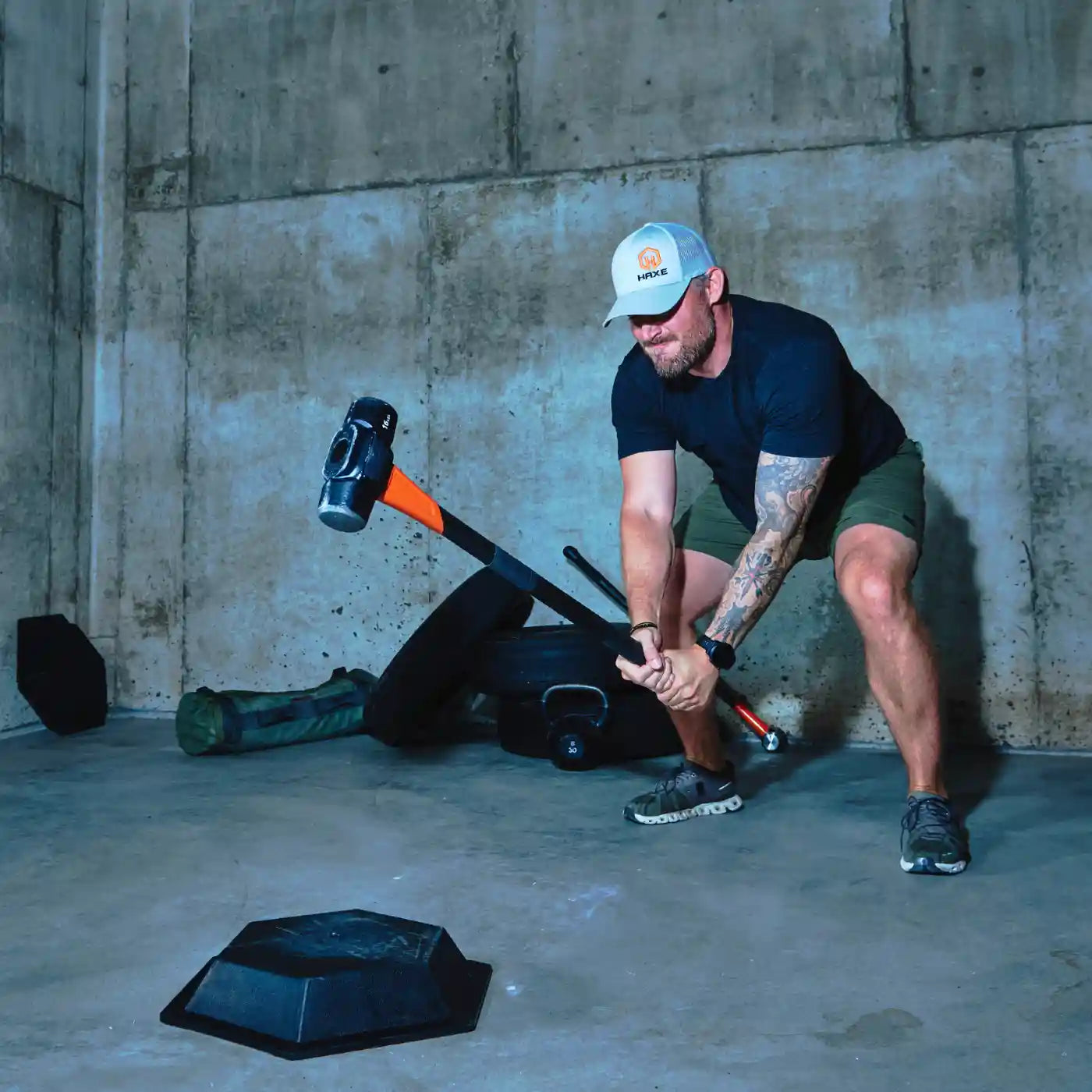 Man performing a sledgehammer slam workout on the HAXE Slam Pad