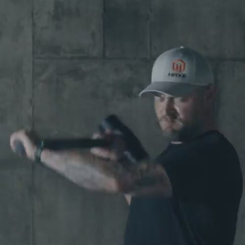 Man and woman using the HAXE Slam Pad with a sledgehammer in a garage gym
